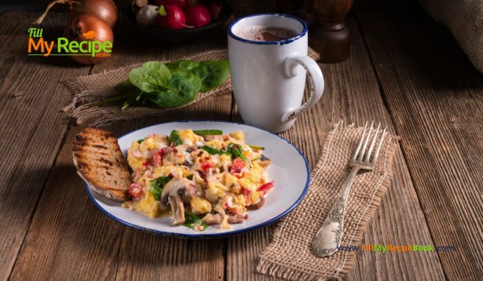 Scrambled Eggs Tomatoes and Spinach recipe for breakfast. Healthy fluffy scrambled eggs in a pan on the stove top, with vegetables on toast.