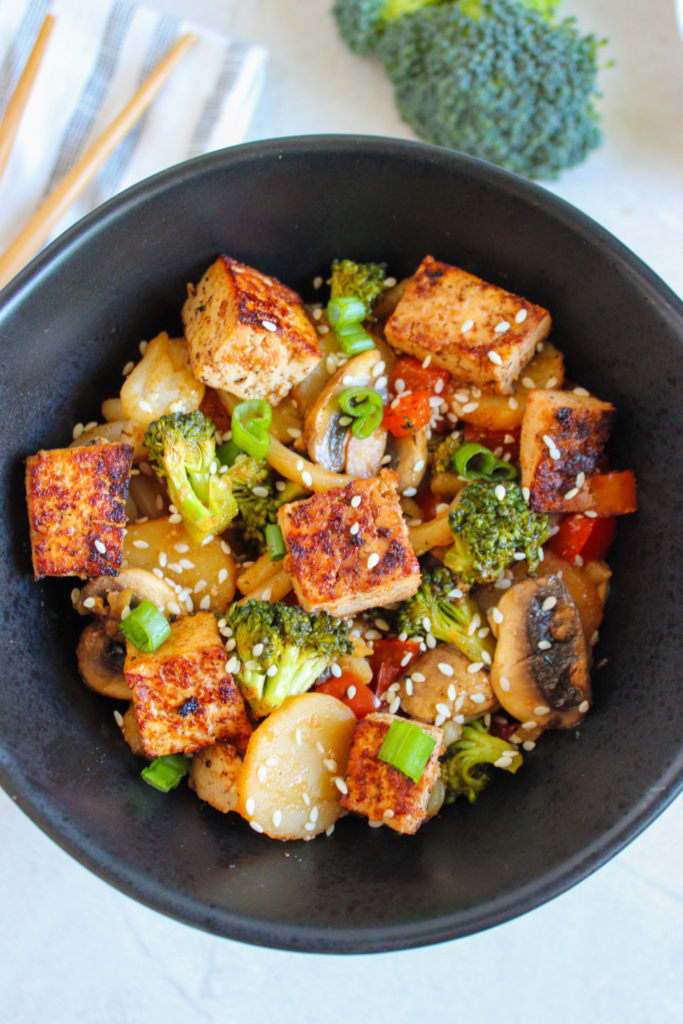 Easy Tofu Veggie Stir Fry Recipe idea with honey and sesame seeds. A no bake healthy vegan or vegetarian meal with udon noodles.