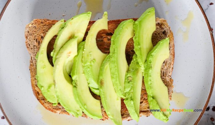 sliced avos, Nutritious Avocado Grated Egg on Toast recipe idea has a crispy bite with buttery avocado and grated boiled egg spiced with lemon pepper.