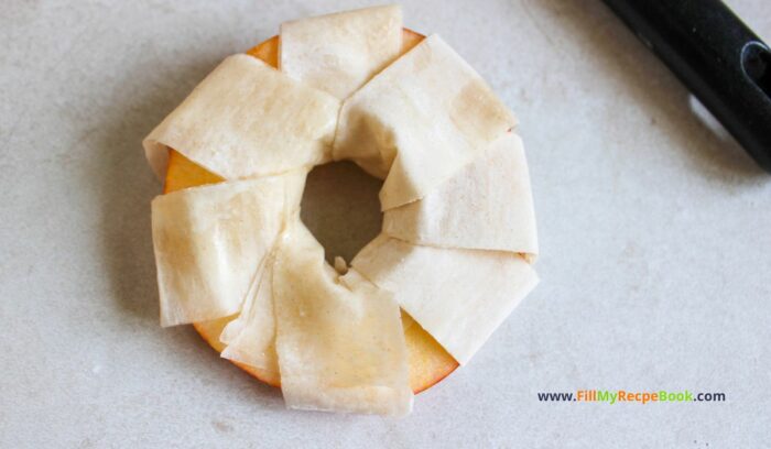 wrapping the apple round with phyllo dough,  Apple Strudel Slices Recipe to have for a sweet dessert. Simple homemade from scratch idea with wrapped phyllo dough on apple rounds, snack.