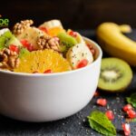 Healthy Kiwi Fruit Salad with Walnuts with pomegranate, orange pieces, banana, chia seeds. An easy recipe idea to create for a winter salad.