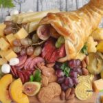 Best Charcuterie Board with Cornucopia recipe idea for Thanksgiving. Bake the easy puff pastry horn and add some fruits, various cheeses.