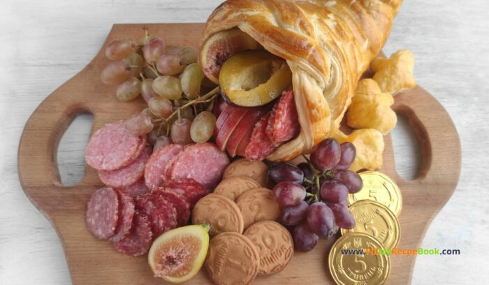 Best Charcuterie Board with Cornucopia recipe idea for Thanksgiving. Bake the easy puff pastry horn and add some fruits, various cheeses.