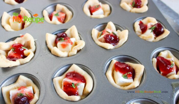 ready to bake ---The most delicious mini Cranberry Brie Puff Pastry Bites appetizer recipe idea. Simple to make ahead for a sweet and savory holiday snack.