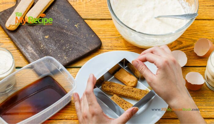 ladyfinger biscuits soaked in espresso coffee, breaking in pieces for the Delicious Tiramisu Trifle in a Glass for individual servings as a dessert. A mini trifle made with finger biscuits, mascarpone cream, and espresso.