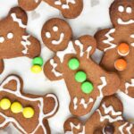 Festive and Easy Gingerbread Men Cookie Recipe Idea for a Delightful Snack. These cookies feature a soft center, crispy edges, and a spicy flavor, all beautifully decorated with a white glaze and mini M&M's.