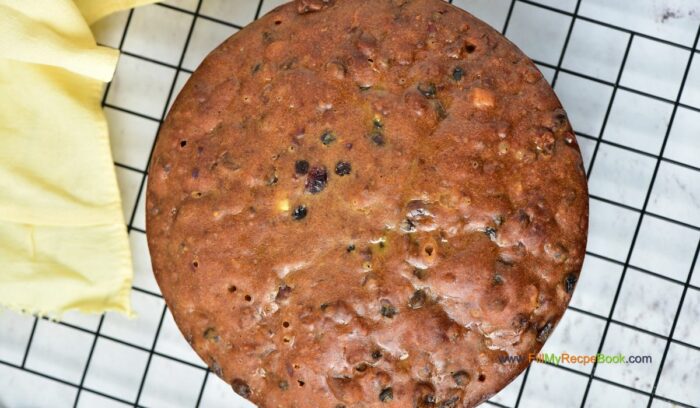 cooling on a rack, Festive Cranberry Christmas Fruit cake recipe with pecan nuts a glaze of orange juice. Moist and alcohol free, simple bake for the holidays.