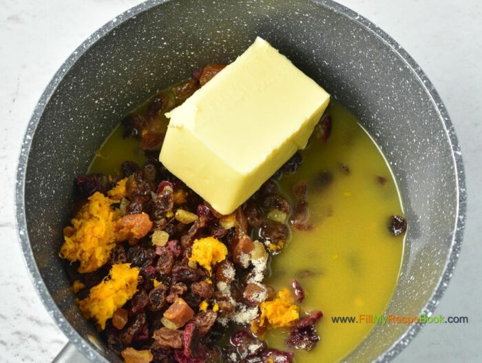 starting to boil the butter and fruits, for Festive Cranberry Christmas Fruit cake recipe with pecan nuts a glaze of orange juice. Moist and alcohol free, simple bake for the holidays.