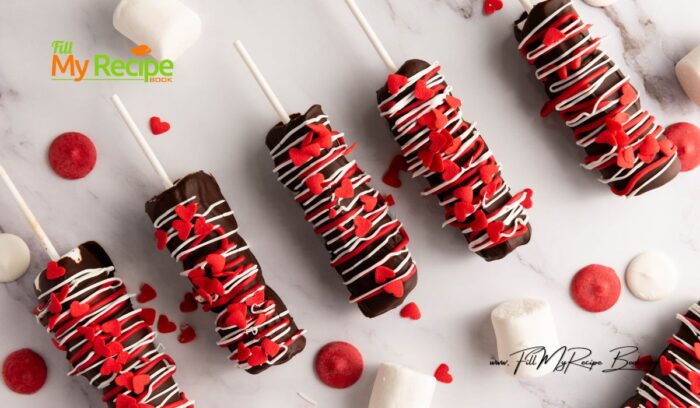 Simple Marshmallow Pops for Valentine's idea for kids. Stack three marshmallows on a stick, dip in chocolate, and add heart sprinkles.