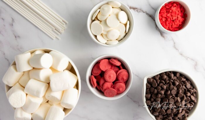 a few simple ingredients for this easy marshmallow snack on a stick coated in melted chocolate and decorated with valentines heart shaped sprinkles.