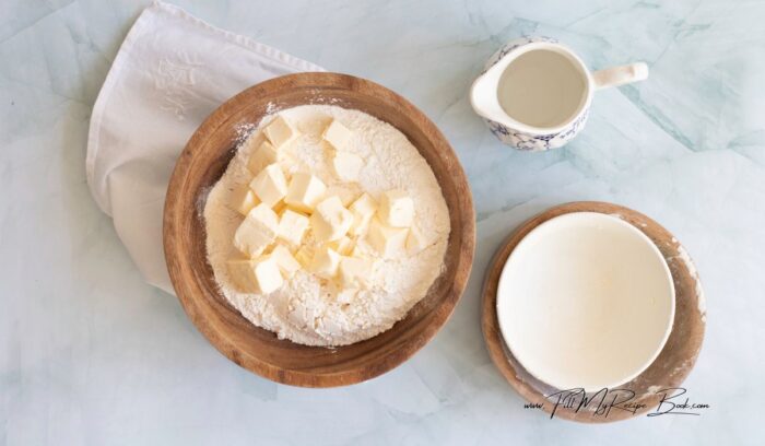 In a large mixing bowl, combine the all-purpose flour and salt. Add the cold, cubed butter to the flour mixture. Mix with your hands until the mixture resembles coarse crumbs.