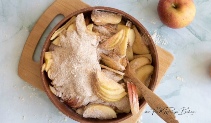 In a large mixing bowl, toss the sliced apples with the lemon juice to prevent browning. In a separate bowl, combine the granulated sugar, brown sugar, all-purpose flour, cinnamon, nutmeg, ginger, and salt. Mix well.