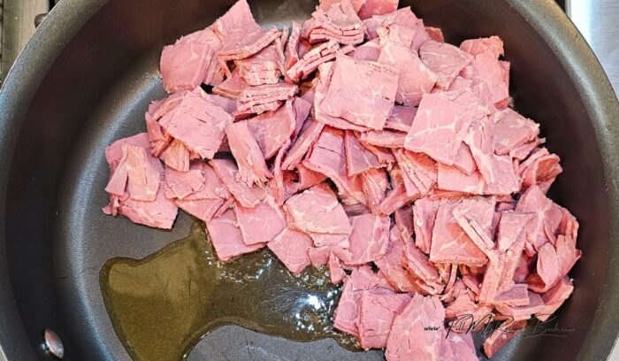 Cut the corned beef into bite sized chunks. this will be fried in the pan on the stove top. then added to the slow cooker vegetablses