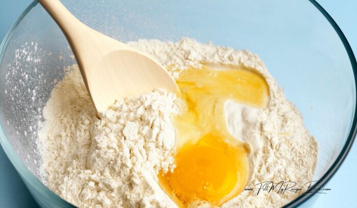 mixing dry with wet ingredients for Quick No Yeast Vetkoek Recipe idea. Crispy South African mouth watering vetkoek made with baking powder fried in hot oil for a meal.