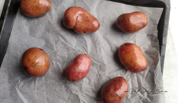 Rinse the potatoes and pat them dry in a towel. Make a few punctures with a fork, brush the vegetables with olive oil on all sides. Place potatoes on a parchment lined baking tray and bake at 200 deg. C (400 deg F.) until soft. About 50 minutes. Test if cooked. 